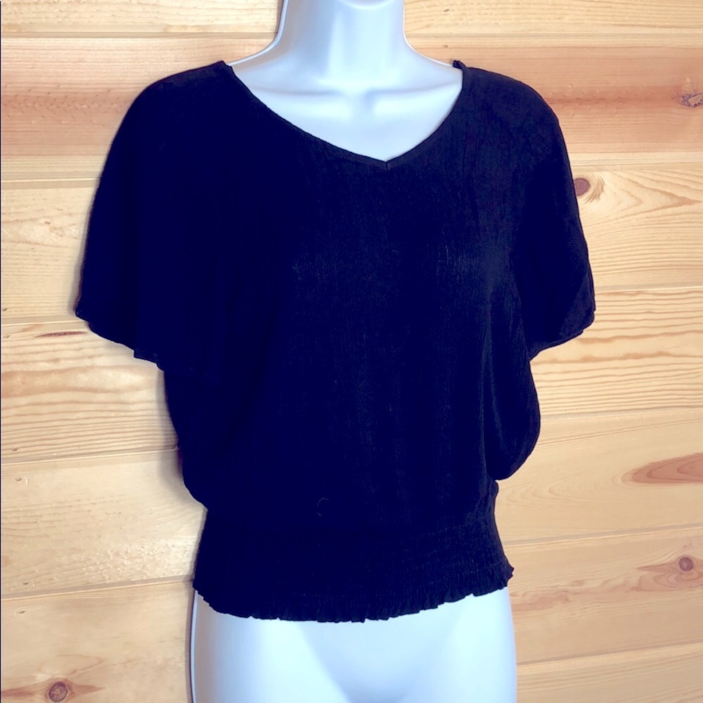 Black top with elastic at waist and tie on back.